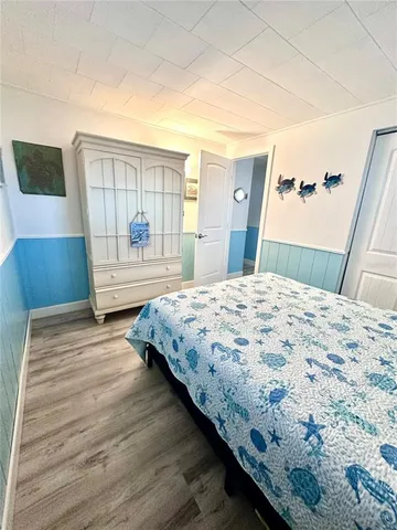 a bedroom with a large bed a rug and wooden floor