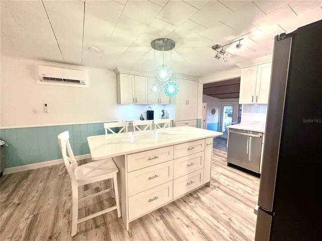 a room with a chair and white cabinets