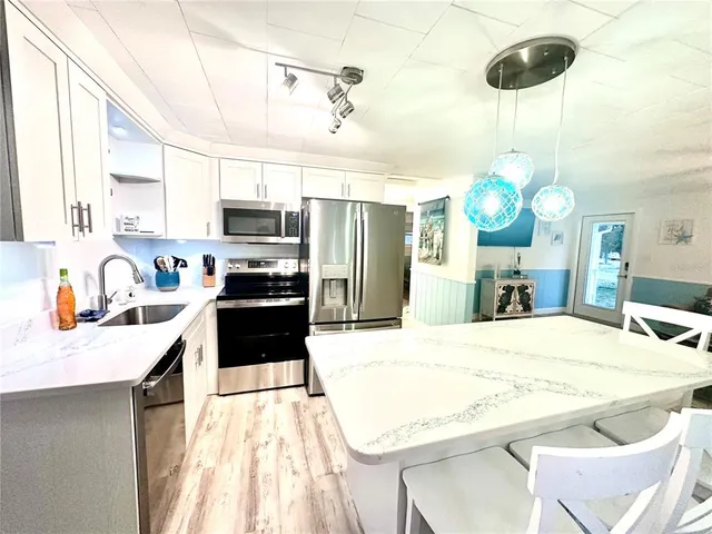 a kitchen with granite countertop a sink cabinets and stainless steel appliances