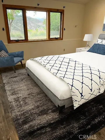 a bedroom with a bed next to a window