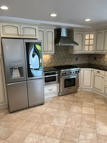 a kitchen with stainless steel appliances granite countertop a stove a sink and a refrigerator