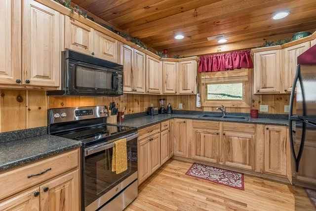 a kitchen with granite countertop a refrigerator stove and sink