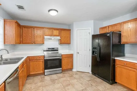 a kitchen with stainless steel appliances granite countertop a stove a refrigerator and a sink