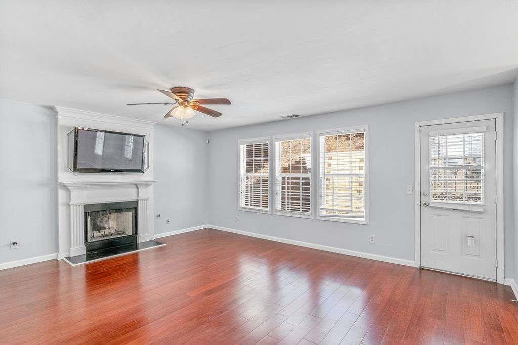 1461 Enchanted Forest Drive Conley, GA 30288 - Photo 17 of 47 wooden floor in an empty room with a fireplace and a window
