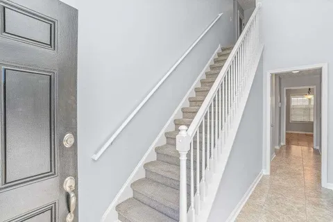 a view of staircase with white walls and railing