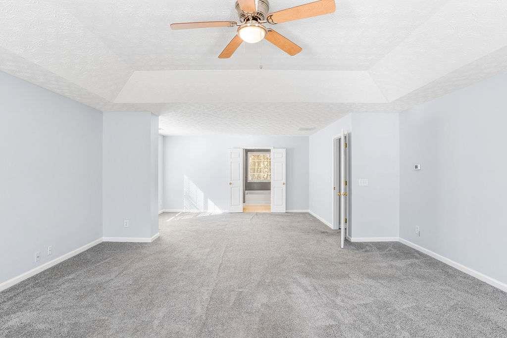 1461 Enchanted Forest Drive Conley, GA 30288 - Photo 27 of 47 an empty room with chandelier fan and windows