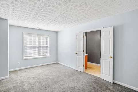 an empty room with a window and a bathroom