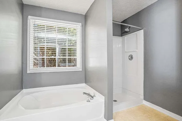a white bath tub sitting next to a shower