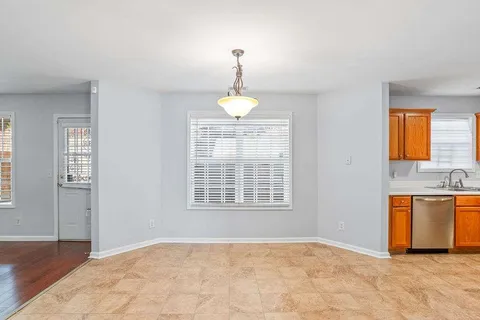 a view of an empty room with window and cabinet