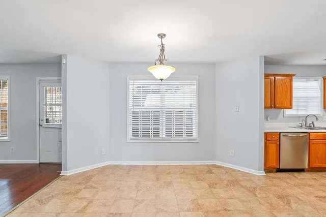 a view of an empty room with window and cabinet