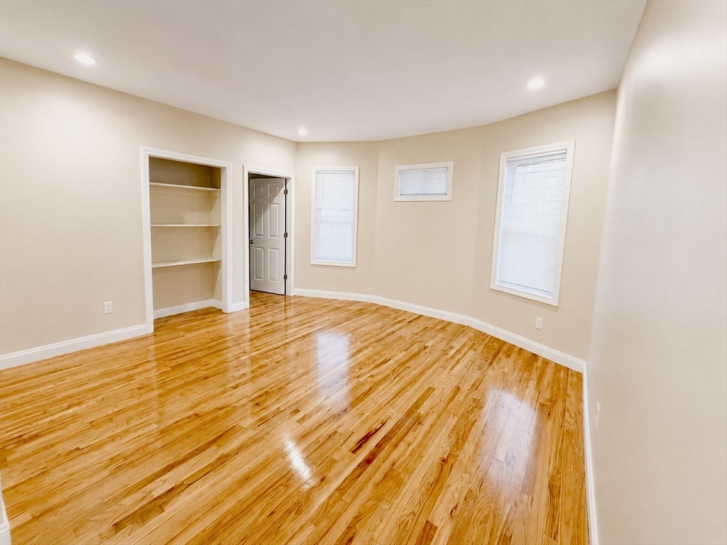 19 Dunlap Street, Unit 1 Boston, MA 02124 - Photo 4 of 9 a view of an empty room with wooden floor and a window