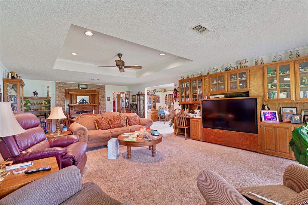 1355 County Road 33100 Sumner, TX 75486 - Photo 25 of 34 Living area featuring light carpet, a textured ceiling, a raised ceiling, a ceiling fan, and recessed lighting
