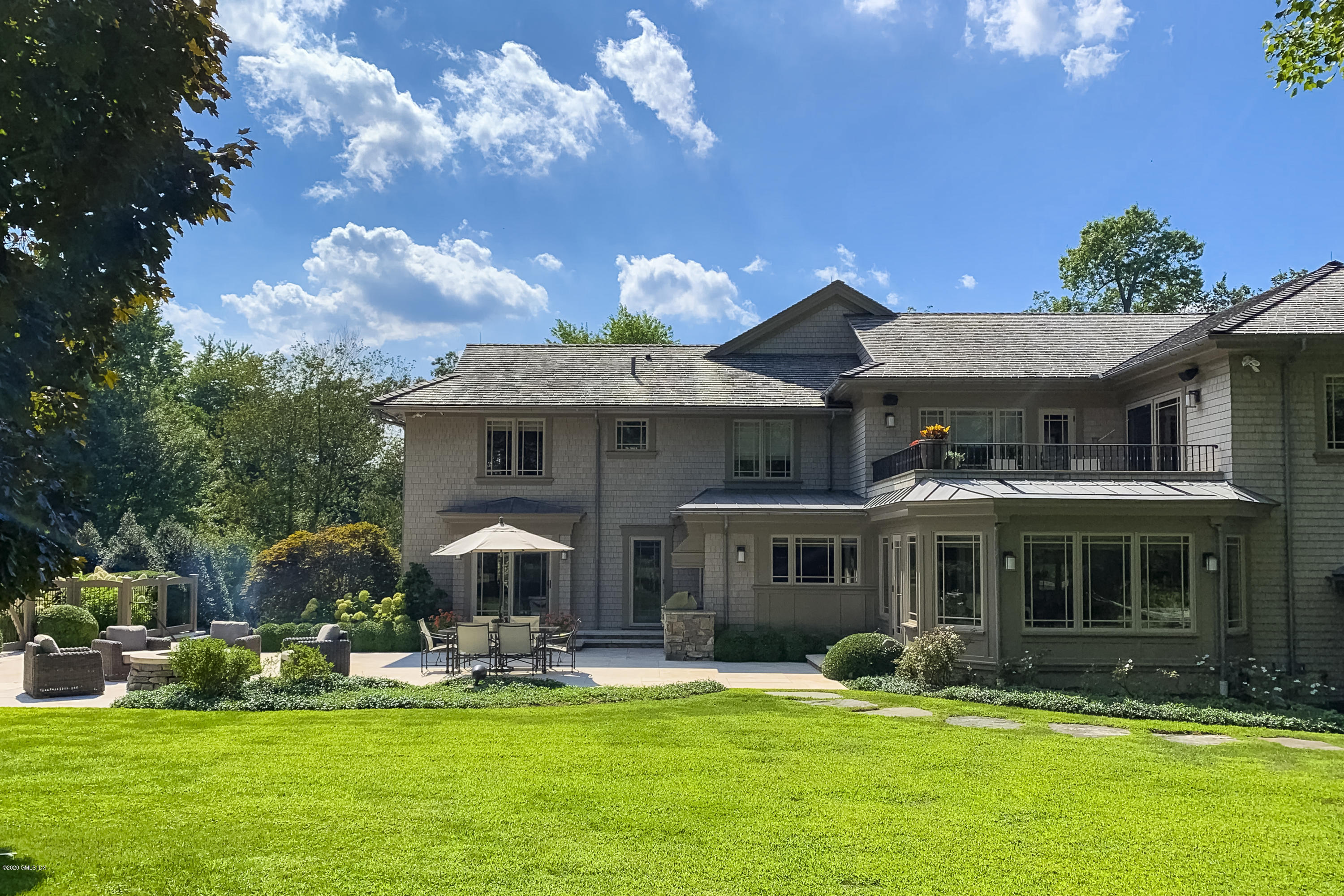 4 Doverton Drive Greenwich, CT 06831 - Photo 14 of 17 a front view of a house with a garden and swimming pool