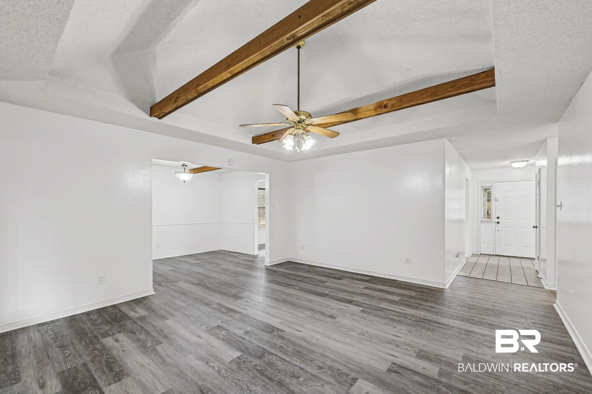 2776 Santa Rosa Circle Lillian, AL 36549 - Photo 15 of 48 Unfurnished living room featuring beam ceiling, dark wood-style floors, and a ceiling fan