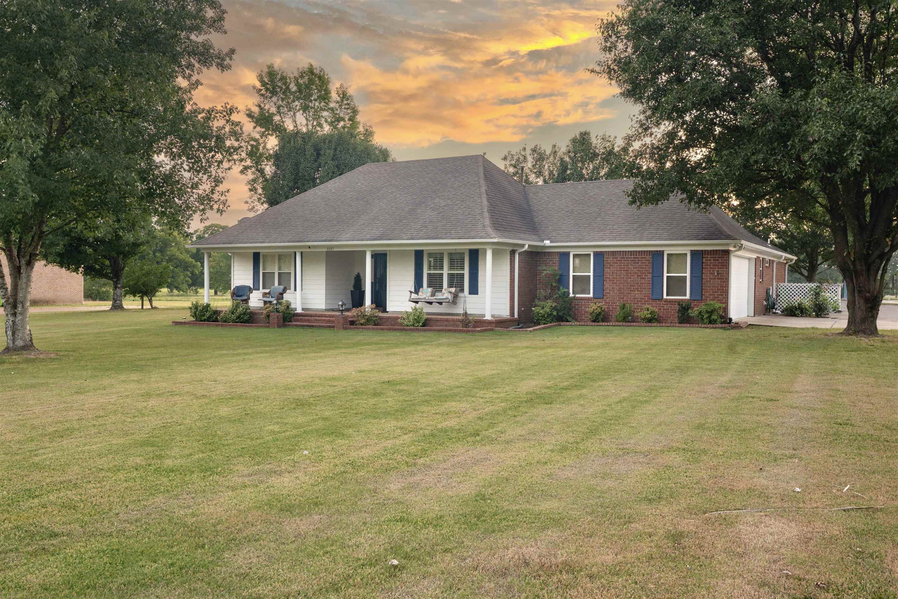 8665 Brunswick Road Millington, TN 38053 - Photo 2 of 39 View of front of home with covered porch, a shingled roof, a garage, brick siding, and a yard