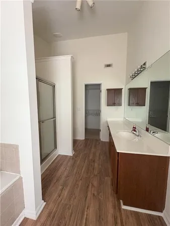 a living room with stainless steel appliances kitchen island granite countertop wooden floors and sink
