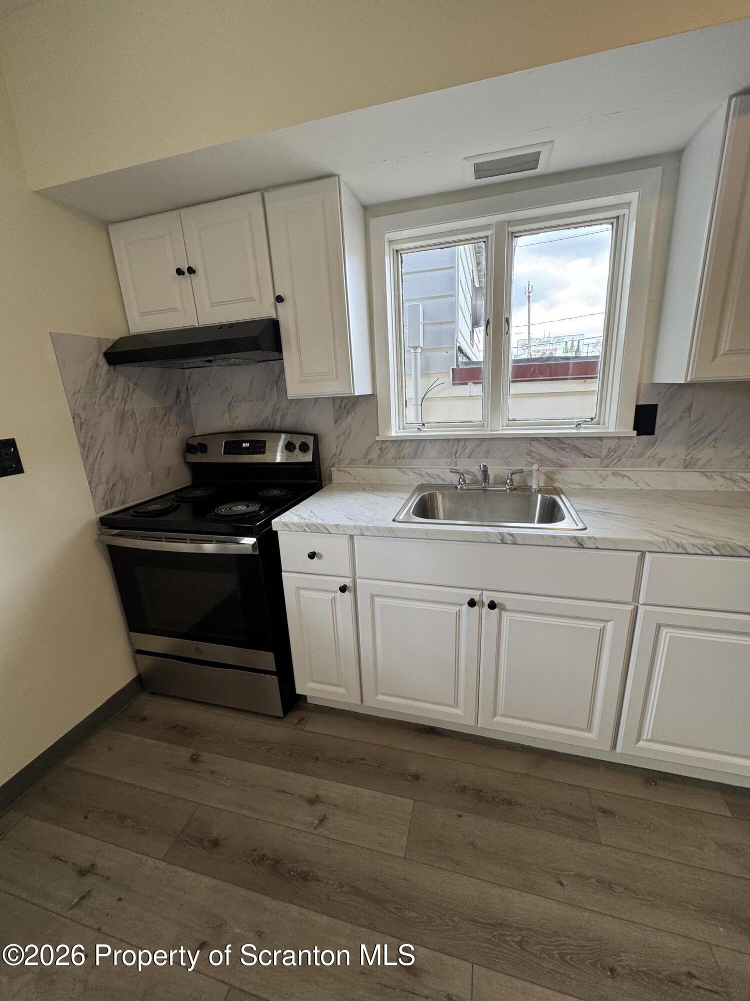 615 3rd Street, Unit 4 Dunmore, PA 18512 - Photo 2 of 17 a kitchen with white cabinets a sink and white appliances