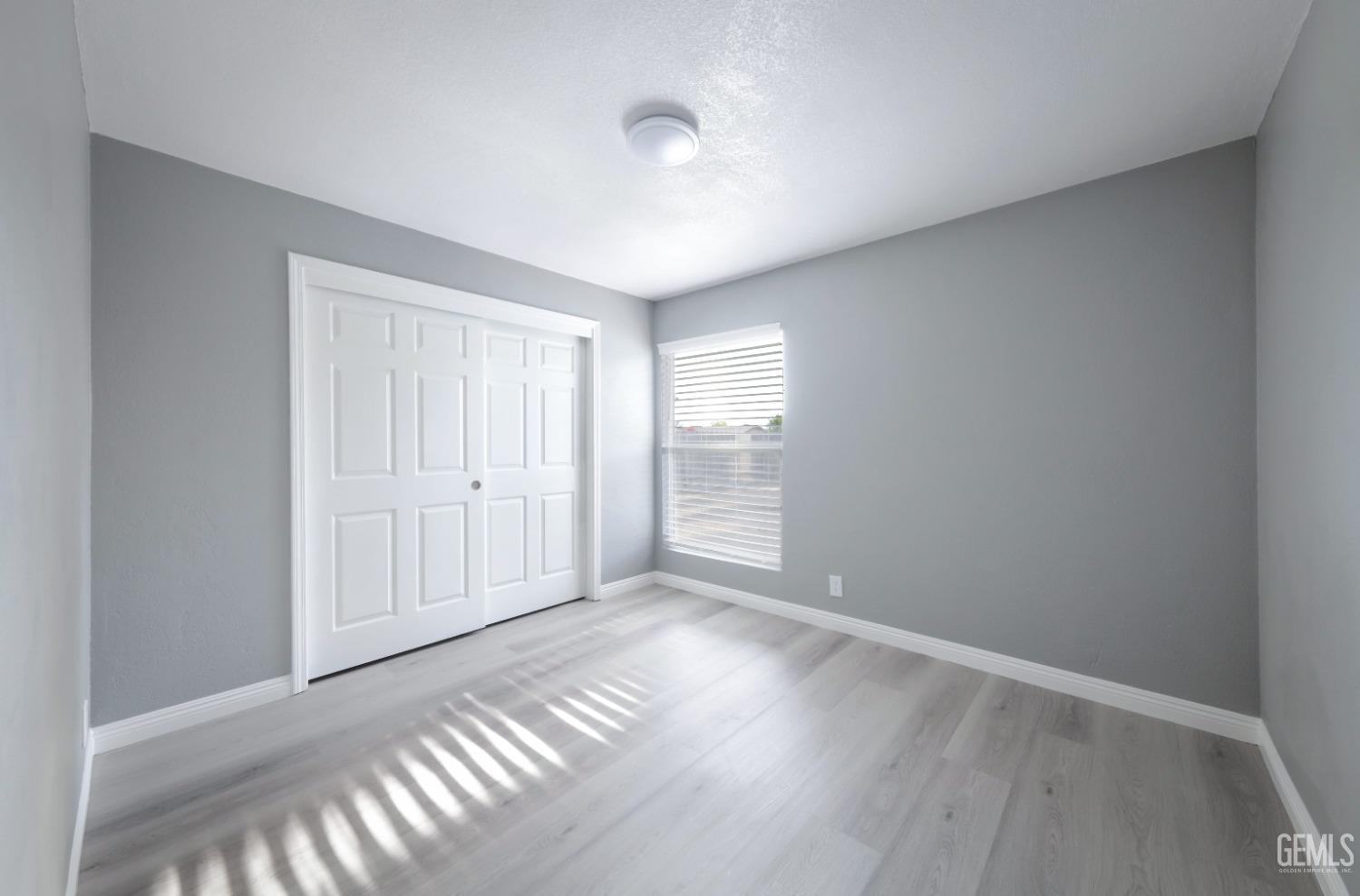 Undisclosed Address Bakersfield, CA 93306 - Photo 12 of 44 a view of an empty room with window and wooden floor
