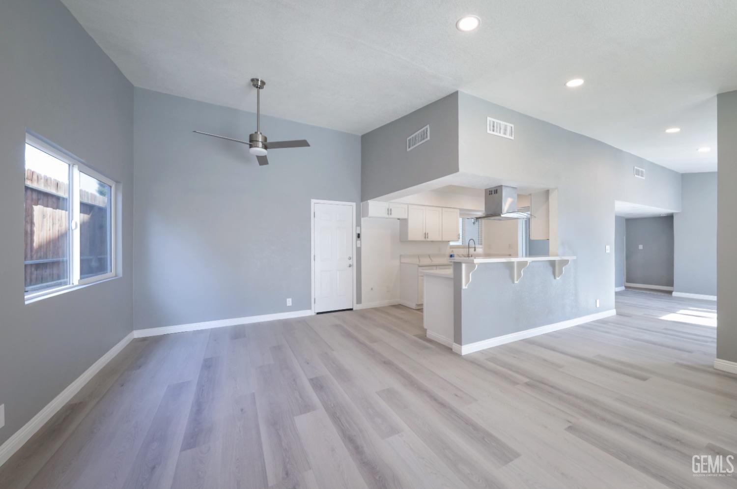 Undisclosed Address Bakersfield, CA 93306 - Photo 31 of 44 a view of a kitchen with wooden floor a refrigerator a ceiling fan and wooden floor