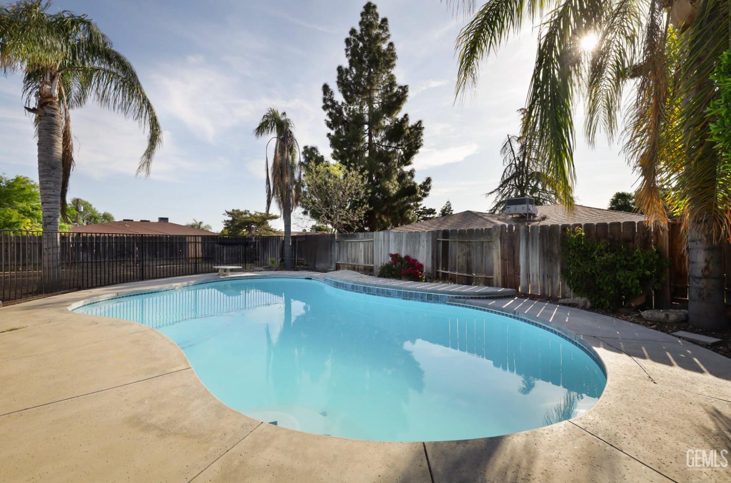 Undisclosed Address Bakersfield, CA 93306 - Photo 36 of 44 a view of a swimming pool with a yard and palm trees
