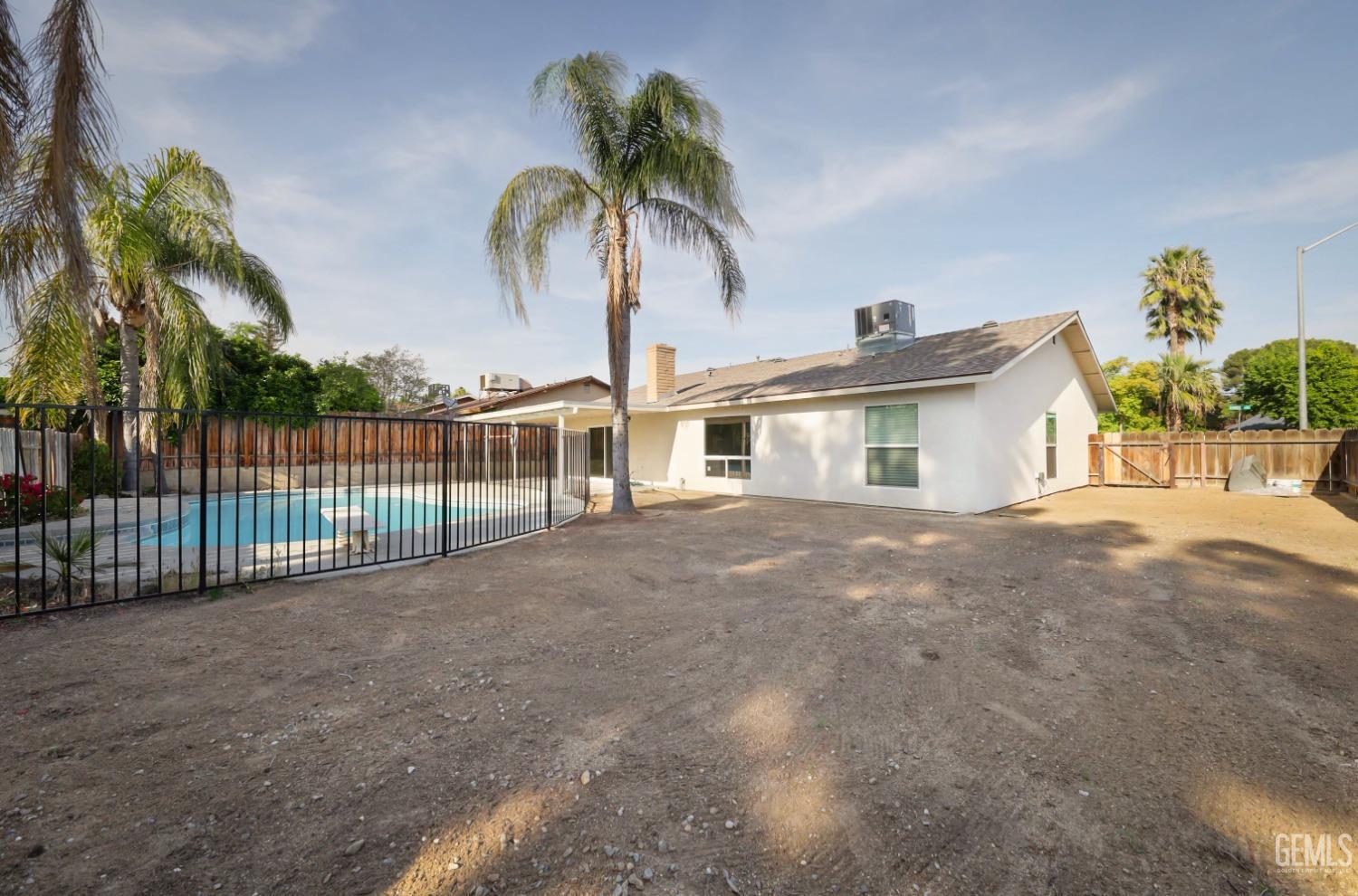 Undisclosed Address Bakersfield, CA 93306 - Photo 40 of 44 a view of a white house with a yard and potted plants