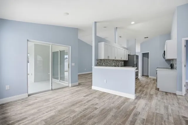 a large kitchen with a wooden floor and stainless steel appliances