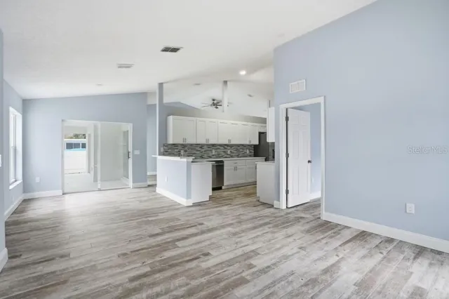 a large kitchen with a wooden floor and stainless steel appliances