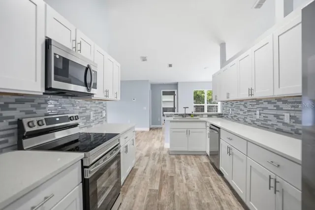 a kitchen with stainless steel appliances granite countertop a stove microwave and sink