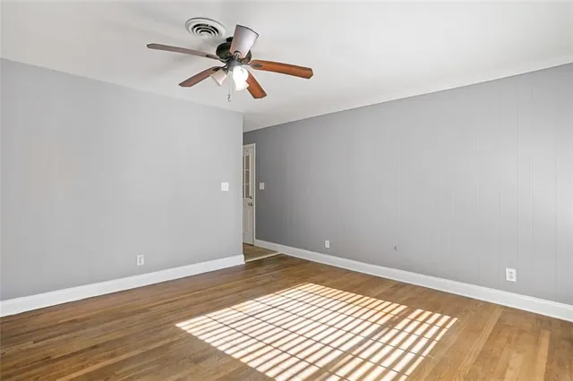 a view of room with wooden floor and ceiling fan