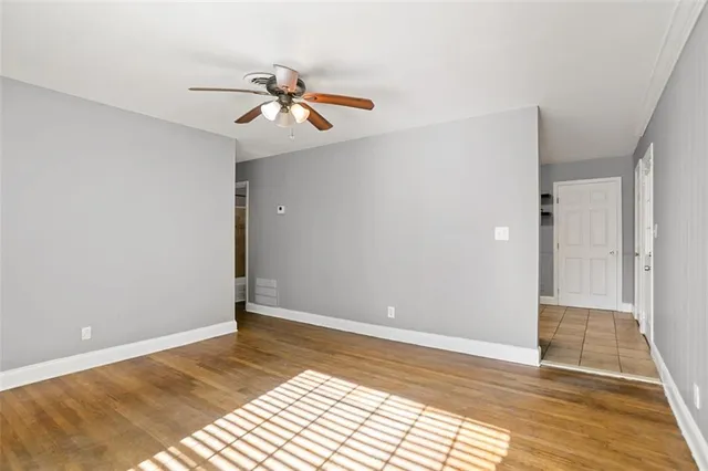 a view of a room with wooden floor and ceiling fan