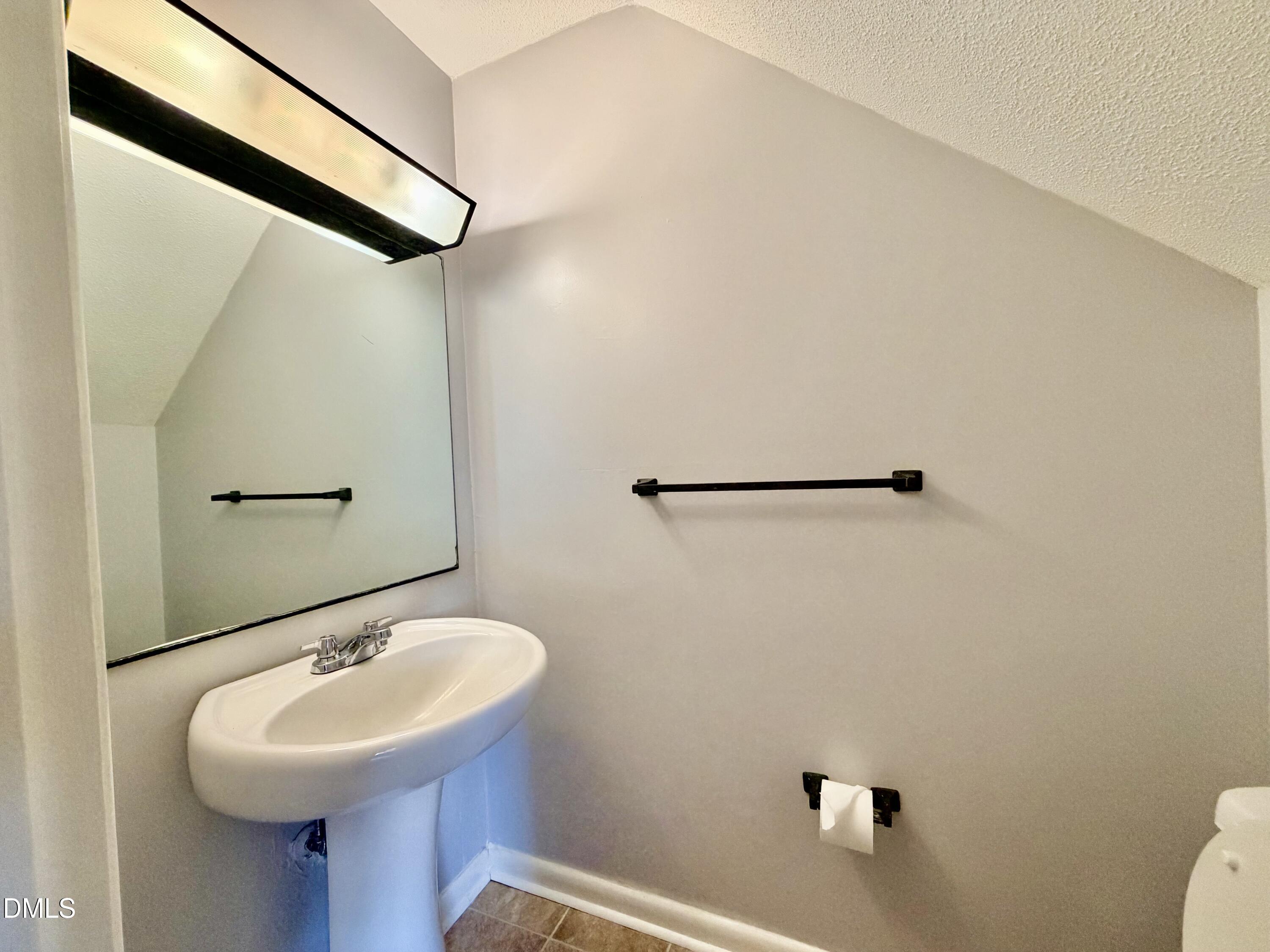 2375 Champion Court Raleigh, NC 27606 - Photo 14 of 31 a bathroom with a sink a mirror and a toilet