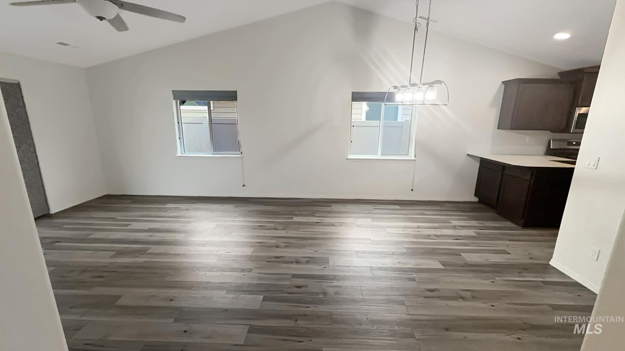 5223 Junegrass Way Caldwell, ID 83607 - Photo 15 of 16 Unfurnished dining area featuring dark wood-style floors, lofted ceiling, a ceiling fan, and suspended lighting