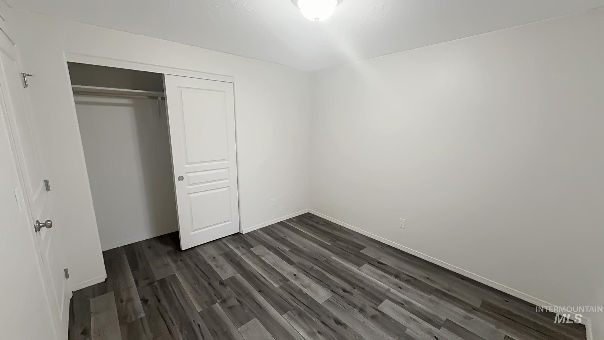 5223 Junegrass Way Caldwell, ID 83607 - Photo 4 of 16 Unfurnished bedroom with dark wood-type flooring and a closet