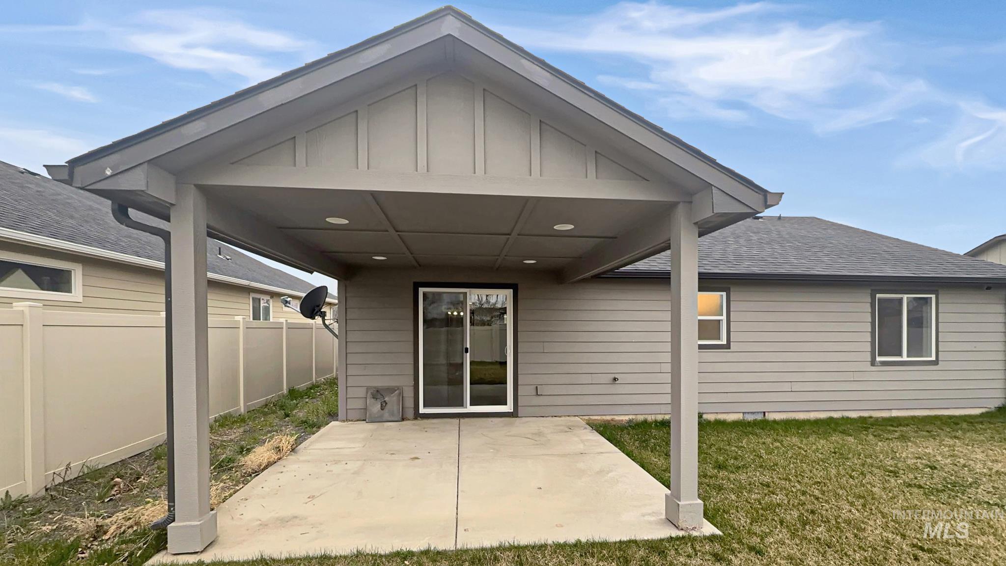5223 Junegrass Way Caldwell, ID 83607 - Photo 5 of 16 Back of property featuring roof with shingles, board and batten siding, and a patio area