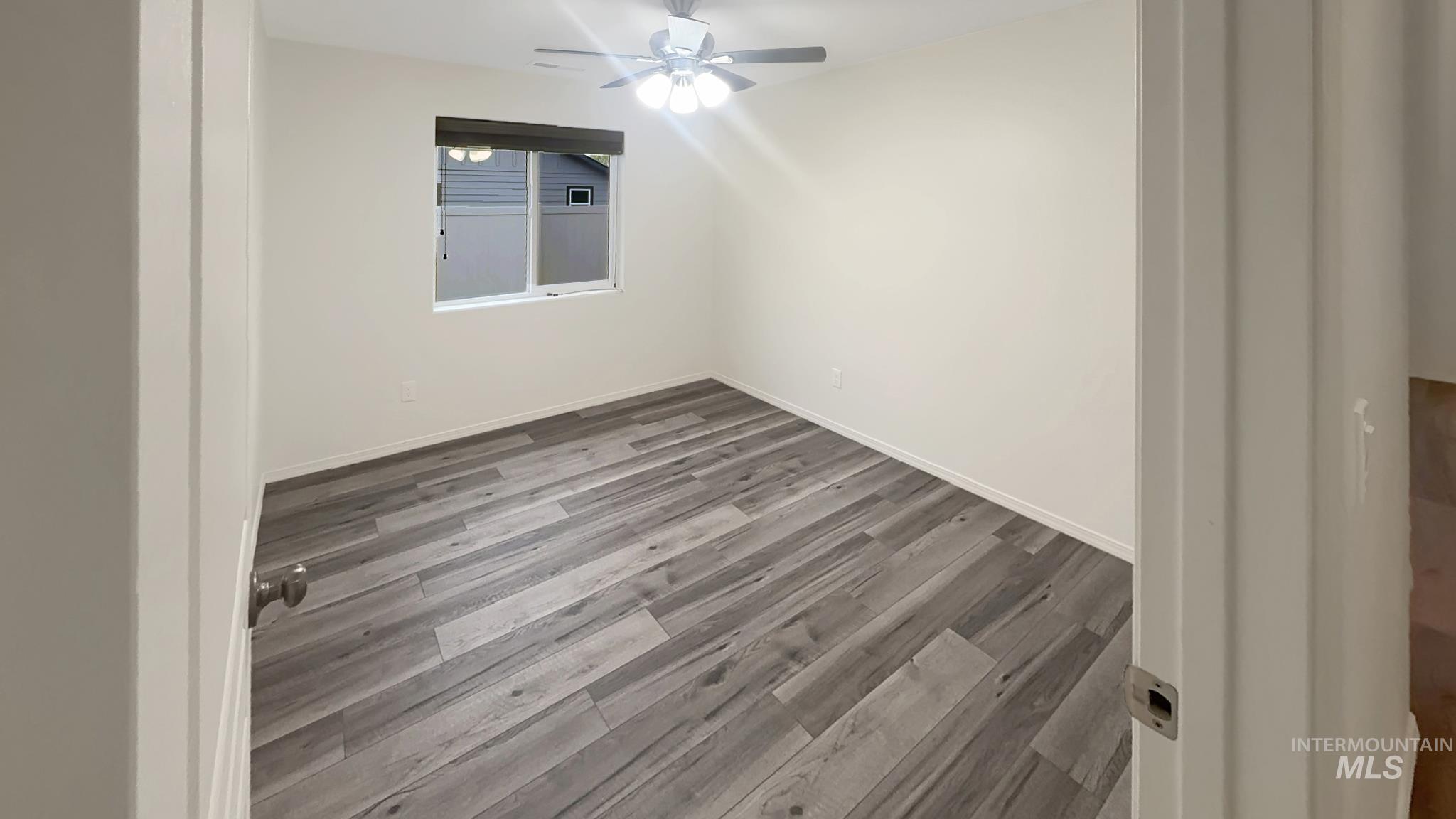 5223 Junegrass Way Caldwell, ID 83607 - Photo 7 of 16 Unfurnished room featuring dark wood-style floors and a ceiling fan