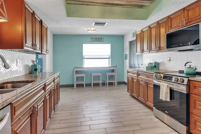 a kitchen with stainless steel appliances a stove a sink and a microwave