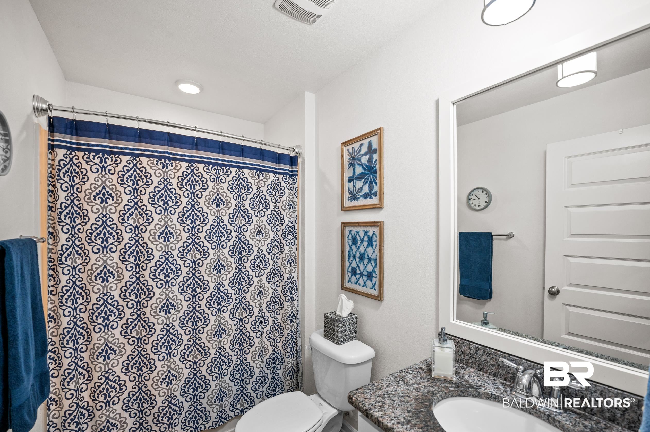 8161 Irwin Loop Daphne, AL 36526 - Photo 26 of 32 Bathroom featuring a shower with curtain, vanity, and toilet