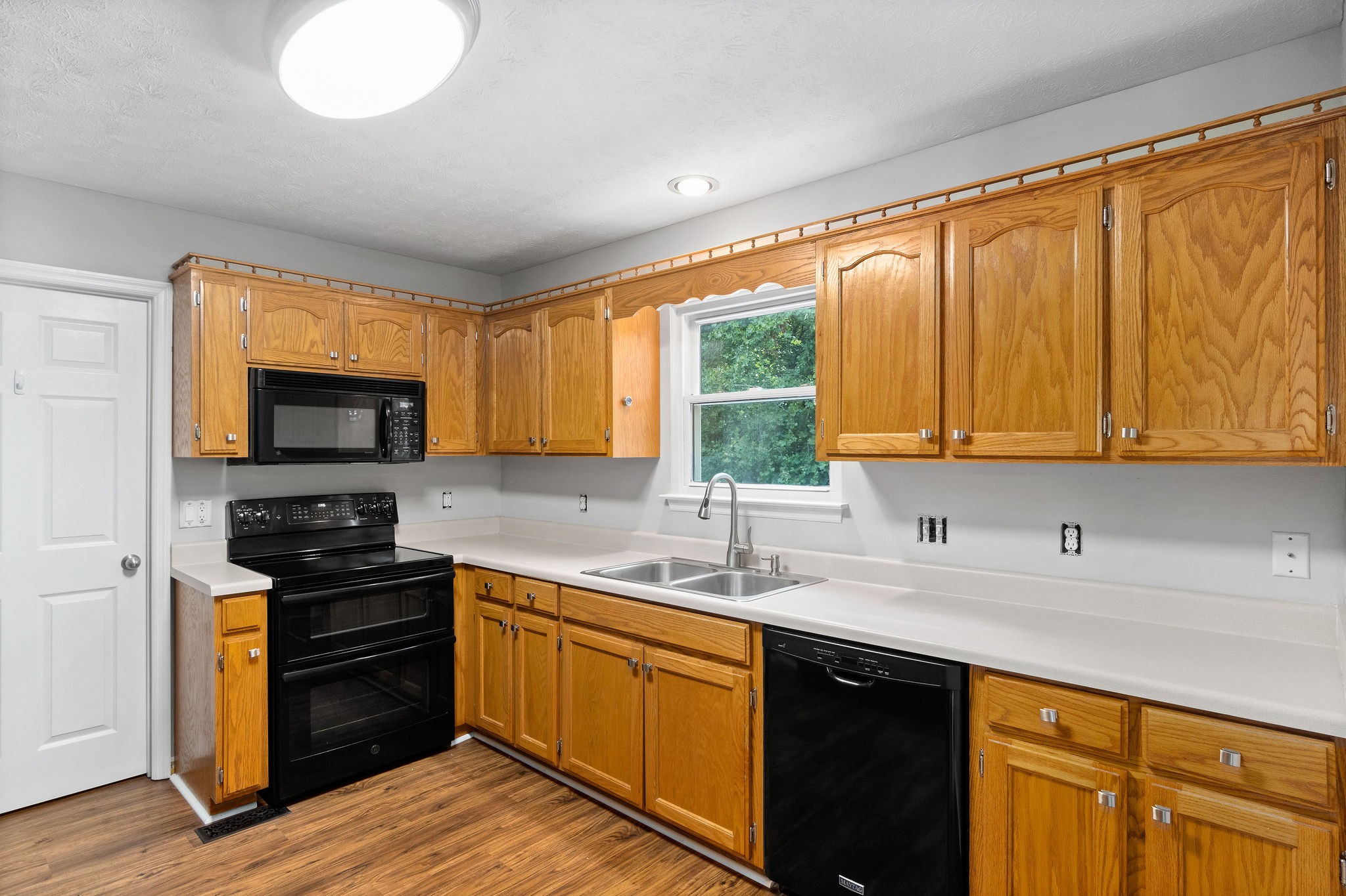 1011 Cherokee Trail Springfield, TN 37172 - Photo 12 of 40 a kitchen with a sink wooden floor and black appliances