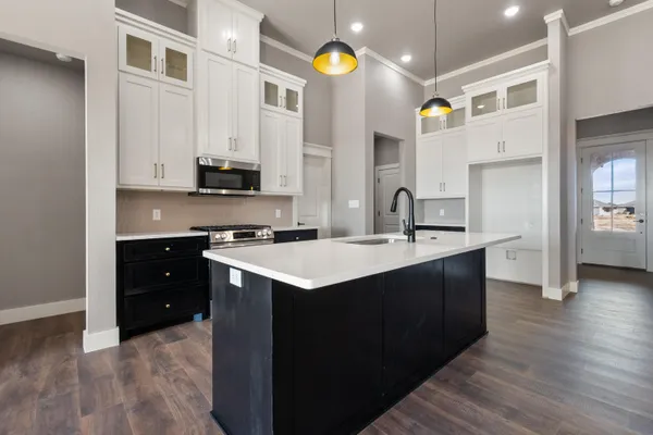 a kitchen with a sink cabinets and wooden floor