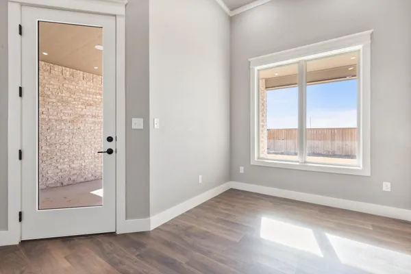 an empty room with wooden floor and a window