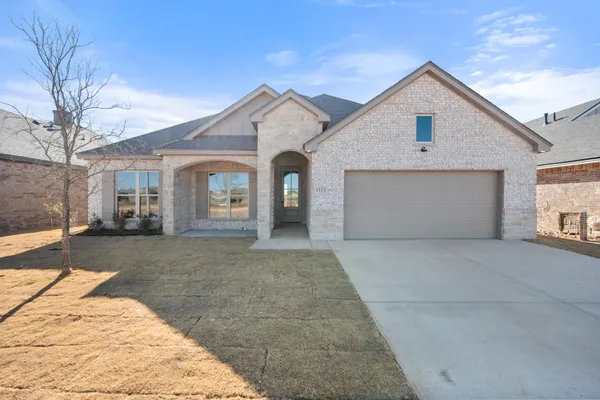 a view of a grey house with a yard