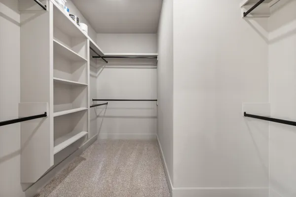 a view of walk in closet with empty racks