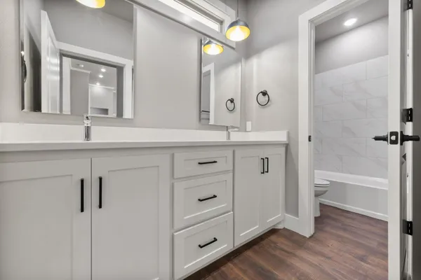 a spacious bathroom with a granite countertop sink mirror and a bathtub