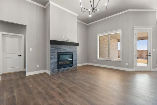 a view of an empty room with glass door and wooden floor