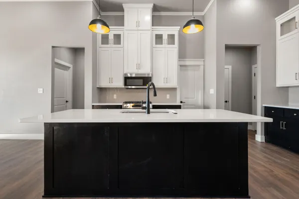a kitchen with stainless steel appliances a sink cabinets and wooden floor