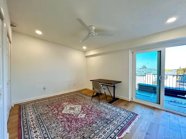 a view of a hallway with wooden floor and a chair
