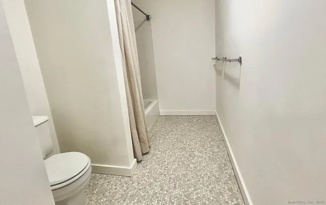 a bathroom with a granite countertop shower and a toilet