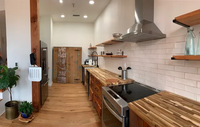 a kitchen with stainless steel appliances granite countertop a sink a stove and a refrigerator