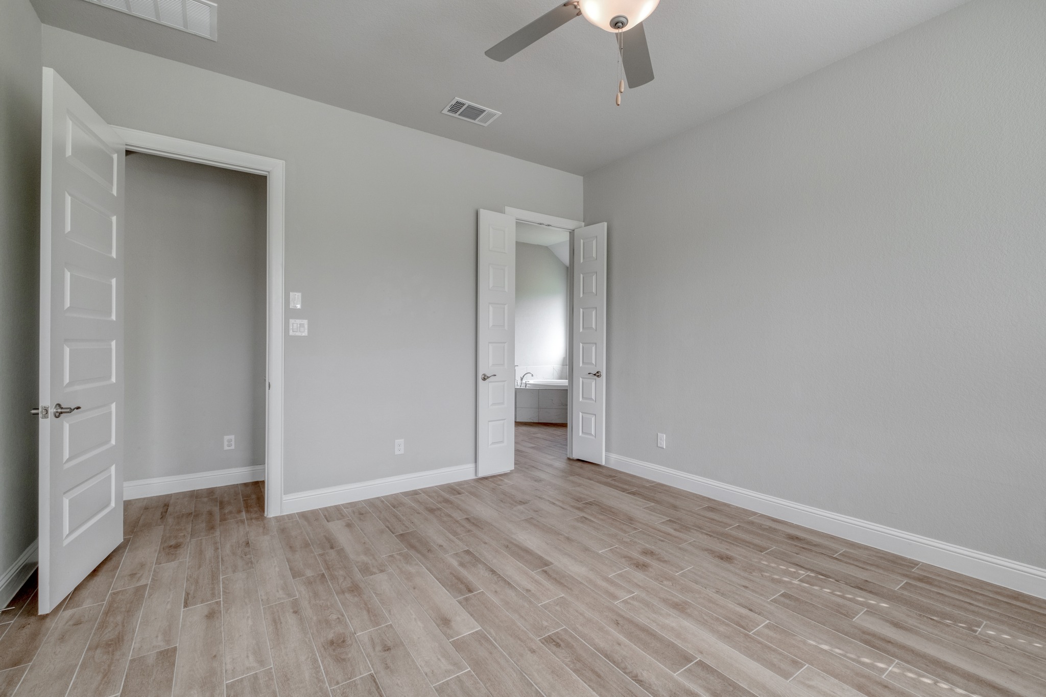 359 Raptor Beak Way Cedar Creek, TX 78612 - Photo 17 of 29 a view of an empty room with wooden floor and a ceiling fan