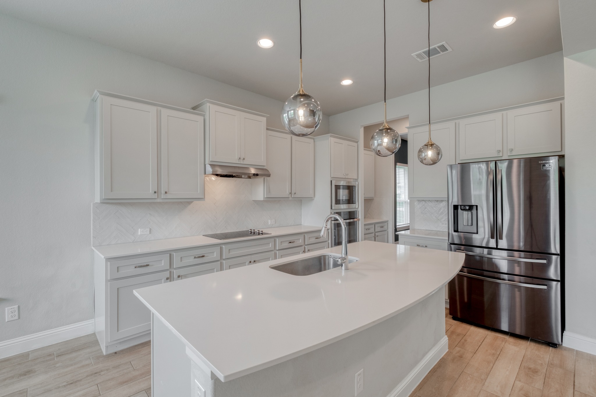 359 Raptor Beak Way Cedar Creek, TX 78612 - Photo 8 of 29 a kitchen with kitchen island a sink stainless steel appliances and wooden floor